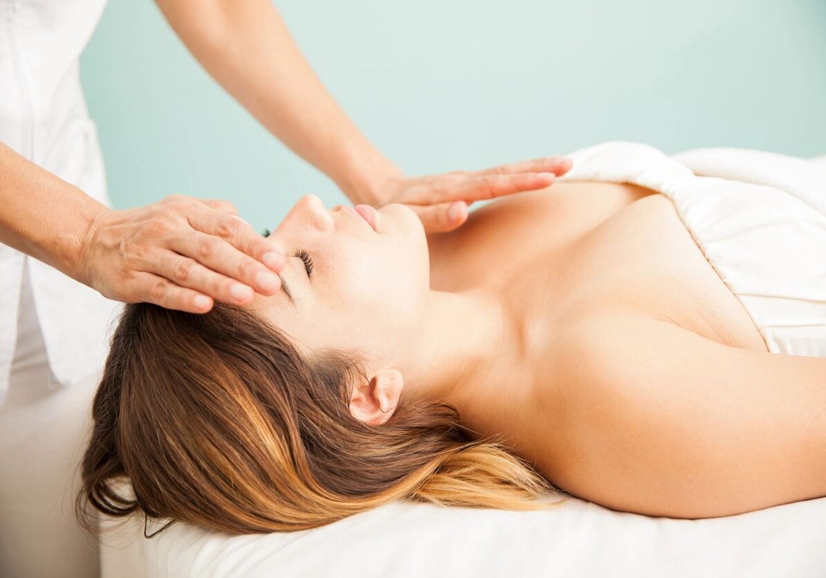 Beautiful young Hispanic woman getting positive vibes during a reiki session at a health clinic and spa